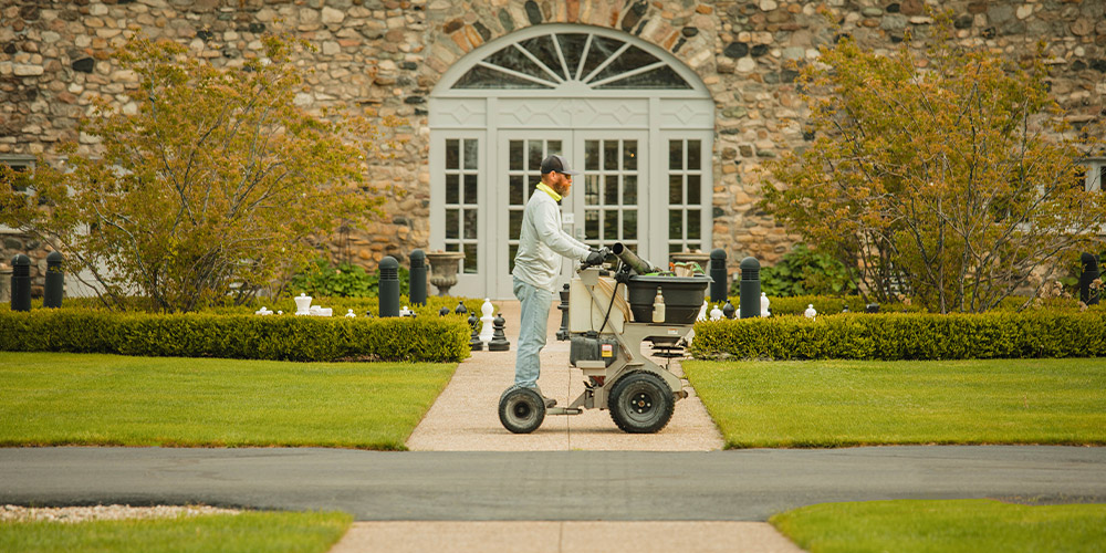 Vidosh North employee fertilizing lawn